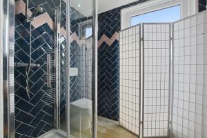 a bathroom with a shower with a glass door at Angel Townhouse in London
