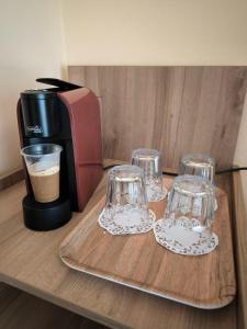 tre bicchieri su un vassoio accanto a una macchina per il caffè di Familia Fantastiko a Kiten
