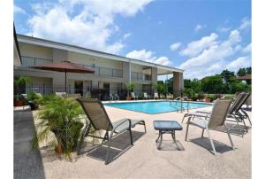 a group of chairs and a table next to a pool at Motel 6-Mobile, AL in Tillmans Corner