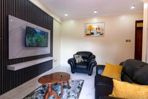 Una sala de estar con un sofá y un televisor. en Goshen Luxury Apartment C1, en Kampala