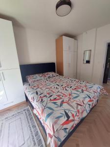 a bedroom with a bed with a colorful comforter at City Vibe Apartment in Tuzla