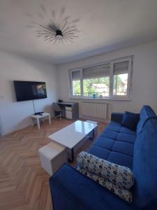 a living room with a blue couch and a table at City Vibe Apartment in Tuzla