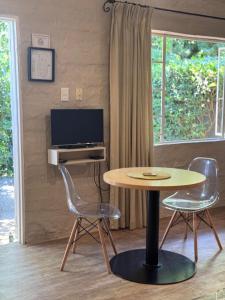 a room with a table and two chairs and a television at Chocolate Orchid in White River