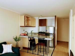 a small kitchen with a counter and a refrigerator at Departamento 2 habitaciones in Temuco