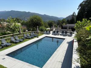 a swimming pool with chaises and chairs next to a house at Gerês Wood Valley in Geres