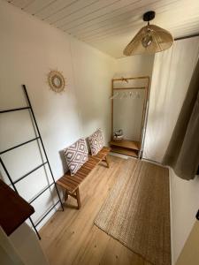 a living room with a bench and a mirror at Cottage au calme Camping Les Tourterelles in La Celle-sous-Gouzon