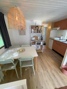 a kitchen and dining room with a table and chairs at Cottage au calme Camping Les Tourterelles in La Celle-sous-Gouzon