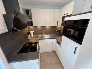 a small kitchen with white cabinets and a sink at Ferienhaus Jannik in Hüde
