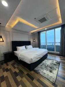 a bedroom with a large bed and a large window at Gold Crest Mall Prestigious Suites with Balcony by CityScape in DHA Lahore in Lahore