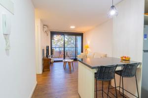 una cucina e un soggiorno con bancone e sedie di Live Soho a Montevideo