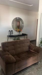 a brown couch in a living room with a mirror at Hotel Royal - Rubiataba in Rubiataba +1 photo