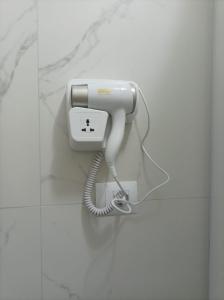 a white phone is hanging on a wall at Alket Rooms for rent in Sarandë +23 photos