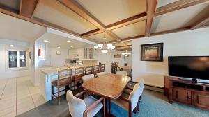 a dining room with a table and a television at Comfortable Condo - Gorgeous Slopeview and Access to 3 Hot Tubs Unit 303 at 1849 in Mammoth Lakes