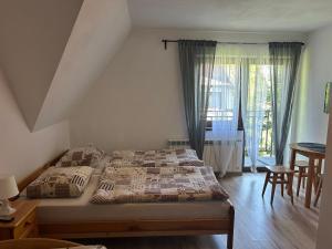 a bedroom with two beds and a table and a window at Willa Agma in Zakopane