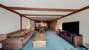 a living room with a couch and a flat screen tv at Retro 3 Bed 3 Bath Condo with Mountain View! Steps to Canyon Lodge! Unit 210 at 1849 in Mammoth Lakes