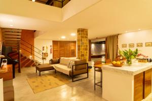 a kitchen and living room with a couch and a table at GreenHousi Boutique Preá in Prea