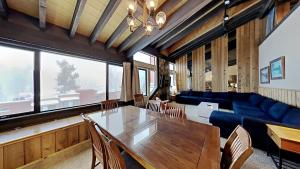 a living room with a table and a blue couch at Cozy 4-Bedroom Home with Pool and Mountain View! in Mammoth Lakes