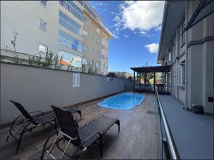 un patio con sillas y una piscina en un edificio en Pousada Casarão Schmidt, en Pomerode