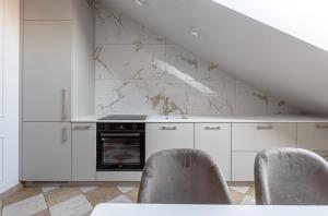 a kitchen with white cabinets and a stove at Traku apartament in Pakopi