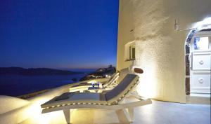 a room with chairs and a view of the ocean at Elegant Santorini House 1 Bedroom Villa Windswept House Amazing Caldera View & Outdoor Hot Tub Oia in Thólos