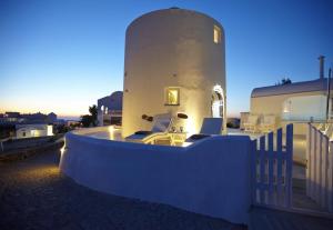 a house with a pool in front of a building at Elegant Santorini House 1 Bedroom Villa Windswept House Amazing Caldera View & Outdoor Hot Tub Oia in Thólos +7 photos