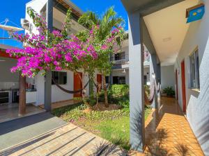 un edificio con un albero con fiori rosa di Pousada Papaya - Bonito a Bonito
