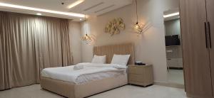 a bedroom with a bed with white sheets and pillows at GC Prestige Premium Family Apartments DHA Lahore in Lahore