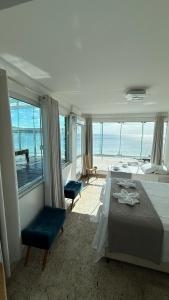 ボンビーニャスにあるTriplex pé na areiaのベッドがあり海が見える寝室 +80枚の写真