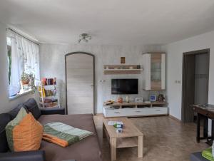 a living room with a couch and a table at Ferienwohnung am Olbasee in Malschwitz
