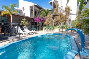 a pool with a water slide in front of a house at Pousada Papaya - Bonito in Bonito