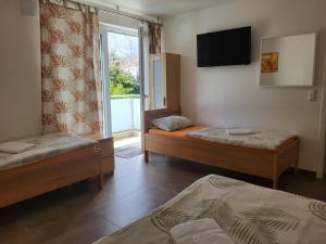 a room with two beds and a tv and a window at Seelze-Letter Monteurzimmer / Apartment / Messezimmer in Seelze