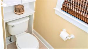 une salle de bain avec des toilettes et un rouleau de papier toilette dans l'établissement Gray Cottage On Windsor, à Cape May