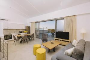 a living room with a couch and a table at Pasiphae Luxury villa in Agia Pelagia