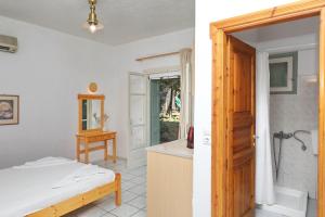 een badkamer met een bed, een douche en een deur bij Pansion Prodromina in Skopelos Town