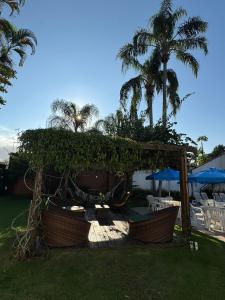 a gazebo with chairs and umbrellas in a yard at Pousada Point Beach - Acácias in Guarujá +20 photos