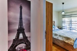 a bedroom with a painting of the eiffel tower at Apartment Alex in Bar