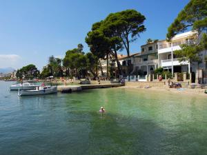 a person swimming in the water near a beach at Charming Mallorca Villa 3 Bedrooms Villa Town House Orion in Port de Pollensa