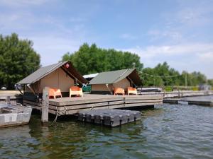 a cabin on a dock on a body of water at Safaritent 1 in Biddinghuizen