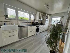 a large kitchen with a sink and a dishwasher at 2 Wohnungen im Refugium 2020 in Marienheide