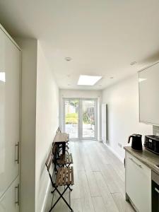 Thornton HeathにあるCharming Two-Bedroom Retreat-Garden Oasis Near Central London & Transport Linksの白い壁のキッチン(カウンタートップ付)