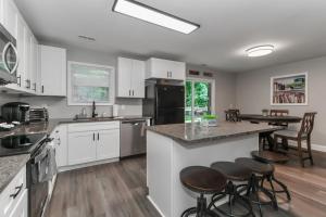 a kitchen with white cabinets and a counter with stools at Gateway to Lake Tillery Retreat in Norwood