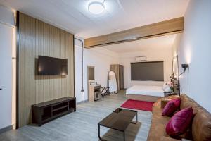 a living room with a couch and a bed and a television at Oasis Suites Pattaya in Pattaya Central