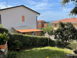 un patio con un seto delante de una casa en Ferienwohnung Dolce Vita Toskana - Massa Marittima mit Parkplatz, Bikeferien meernah, en Massa Marittima