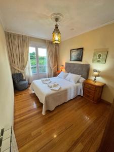 een slaapkamer met een groot bed en een raam bij Apartamento Arnela Foz in Foz