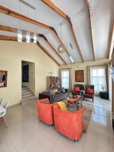 New, modern, airy luxurious 3 bed Home,Monavale Strathaven في هراري: غرفة معيشة كبيرة مع كراسي حمراء وأريكة +26 صورة