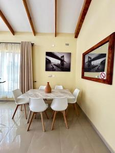 New, modern, airy luxurious 3 bed Home,Monavale Strathaven في هراري: غرفة طعام مع طاولة وكراسي بيضاء