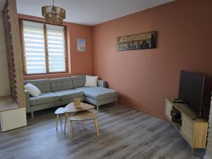 a living room with a couch and a tv at La Voie des Dunes in Bray-Dunes