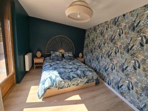 a bedroom with a bed with a large wall at La Voie des Dunes in Bray-Dunes