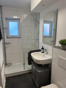 a white bathroom with a sink and a shower at C&V 4 Personen 3 Zimmer Central Smart TV Boxspringbett in Kaiserslautern