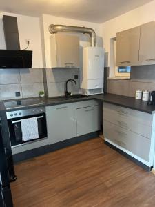 a kitchen with a sink and a stove at C&V 4 Personen 3 Zimmer Central Smart TV Boxspringbett in Kaiserslautern